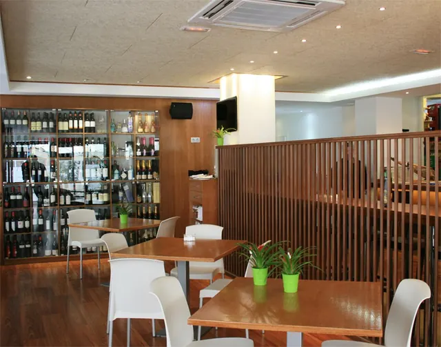 Comedor con mesas de madera y celosía lacada