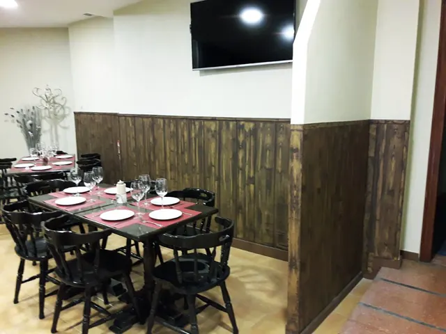 Mesas del comedor junto al zócalo de madera de veta marcada