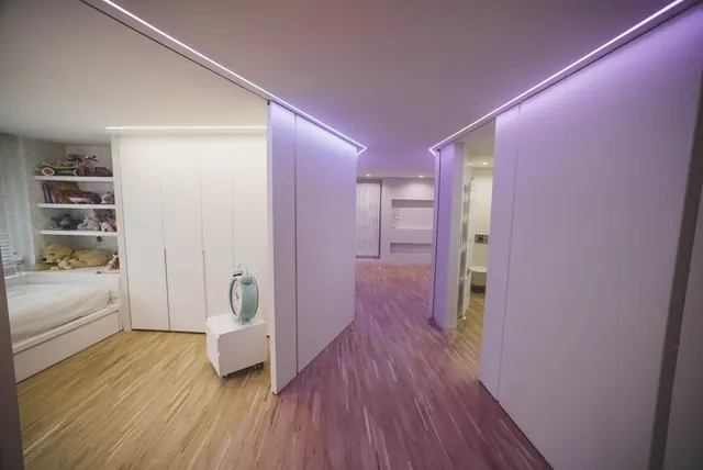 Pasillo con grandes tabiques correderos lacados en blanco